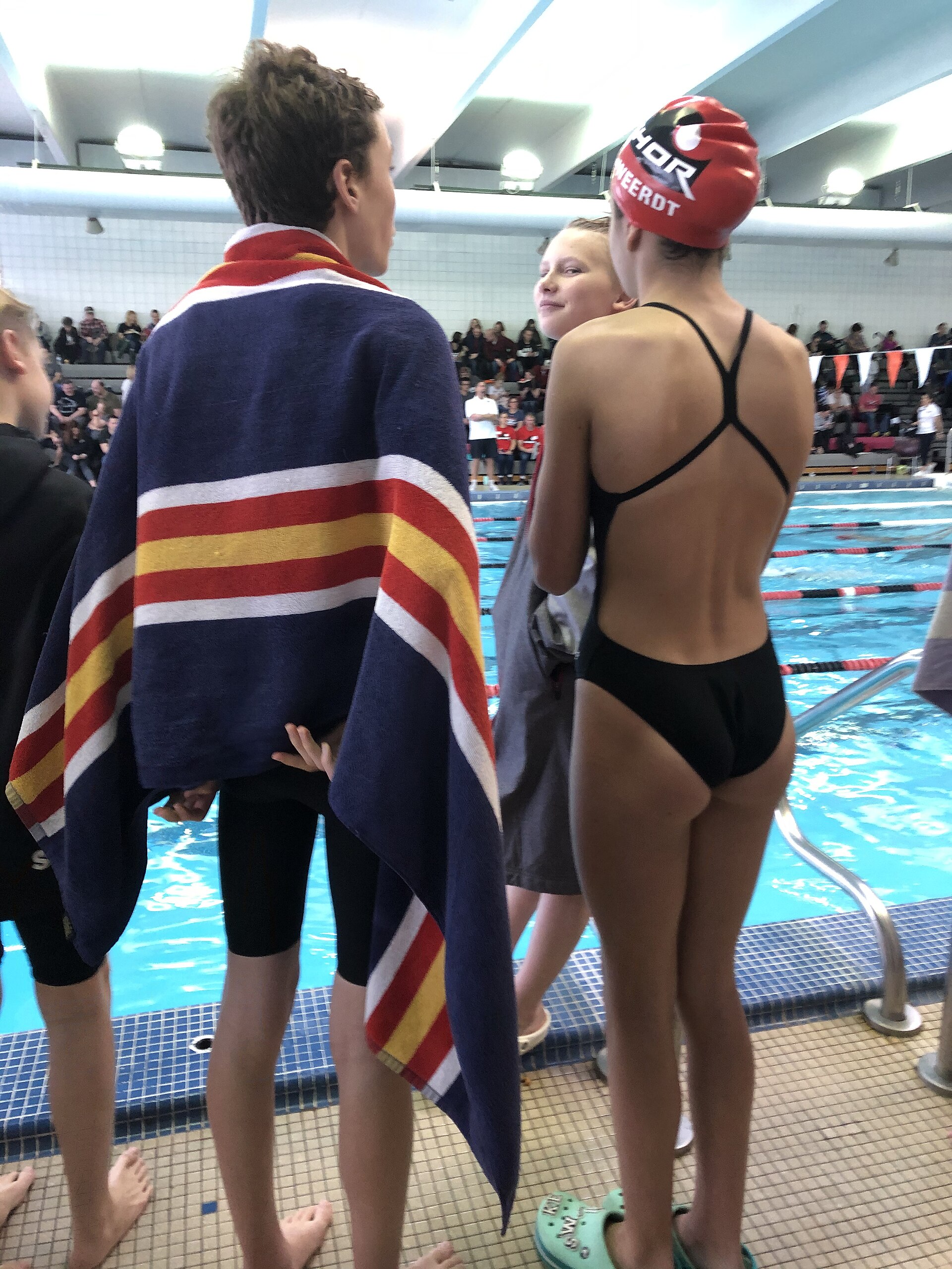 Swimmers beside a lane-lined training pool