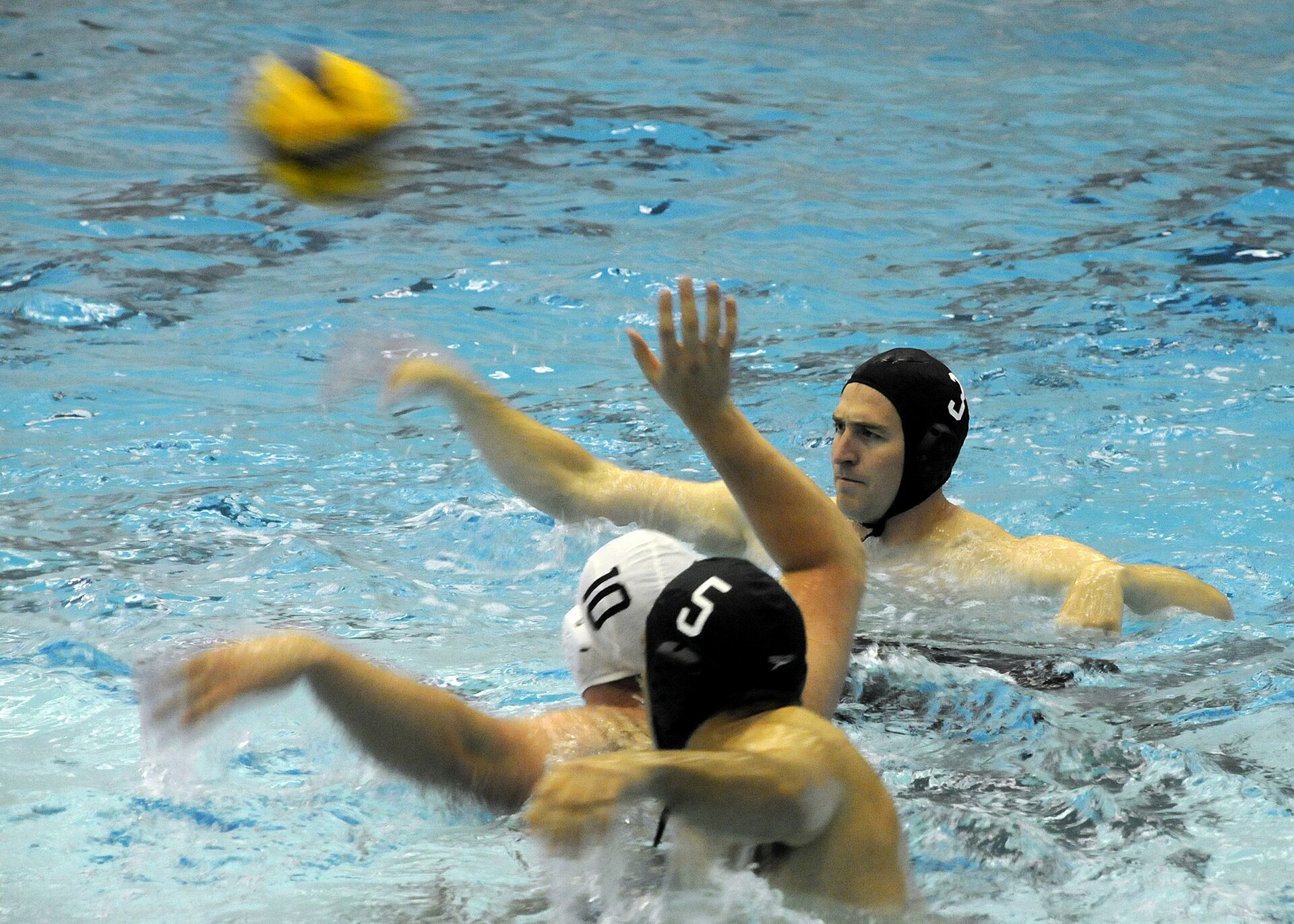 Water polo players passing the ball during a club game